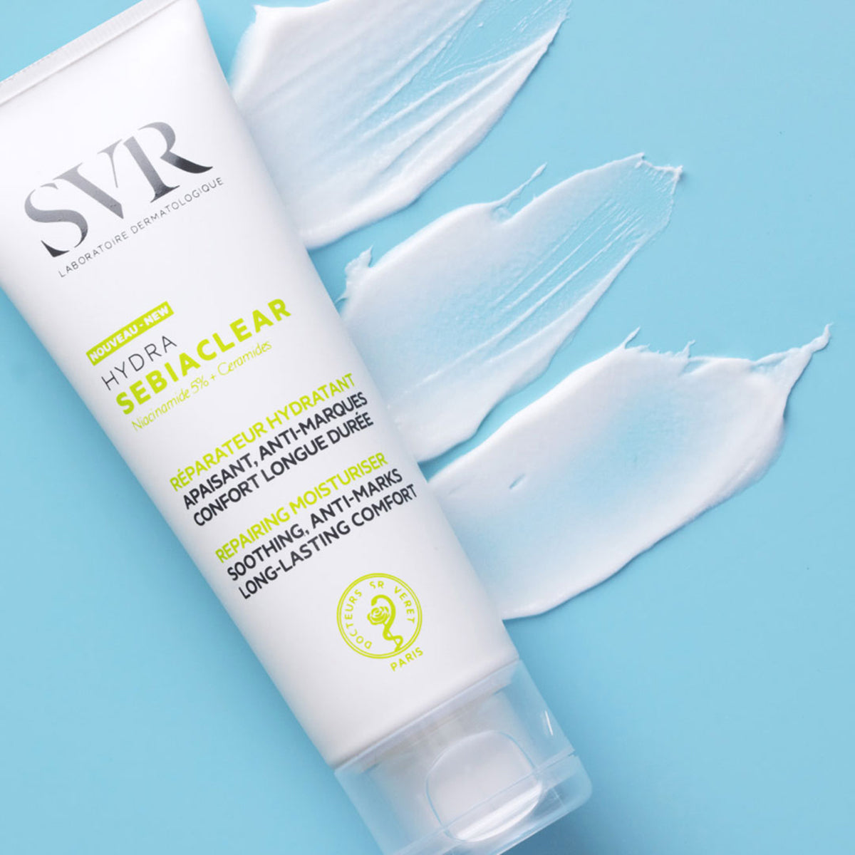 Tube de soin hydratant SVR Sebiaclear Hydra blanc avec trois touches de crème blanche sur fond bleu clair.