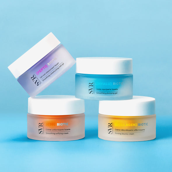 Quatre pots de crème SVR Biotic aux couleurs pastel sur fond bleu, incluant le gel Hyalu Biotic à la texture givrée.