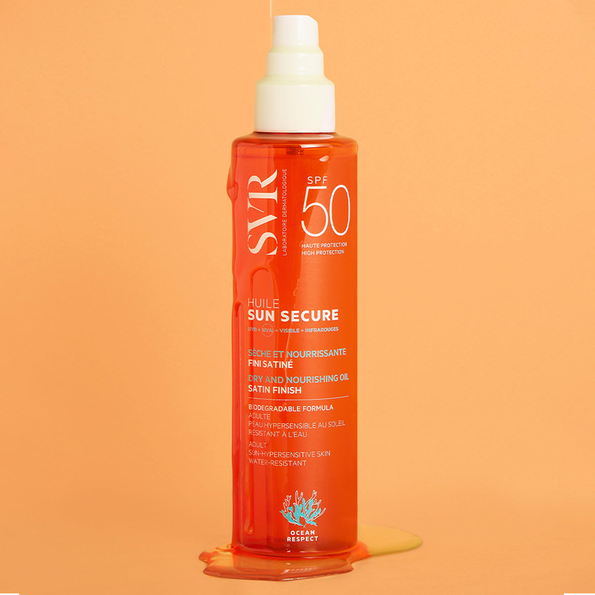 Flacon spray SVR SUN SECURE Huile SPF50 orange avec texture huileuse coulante sur fond pêche, format 200ml.