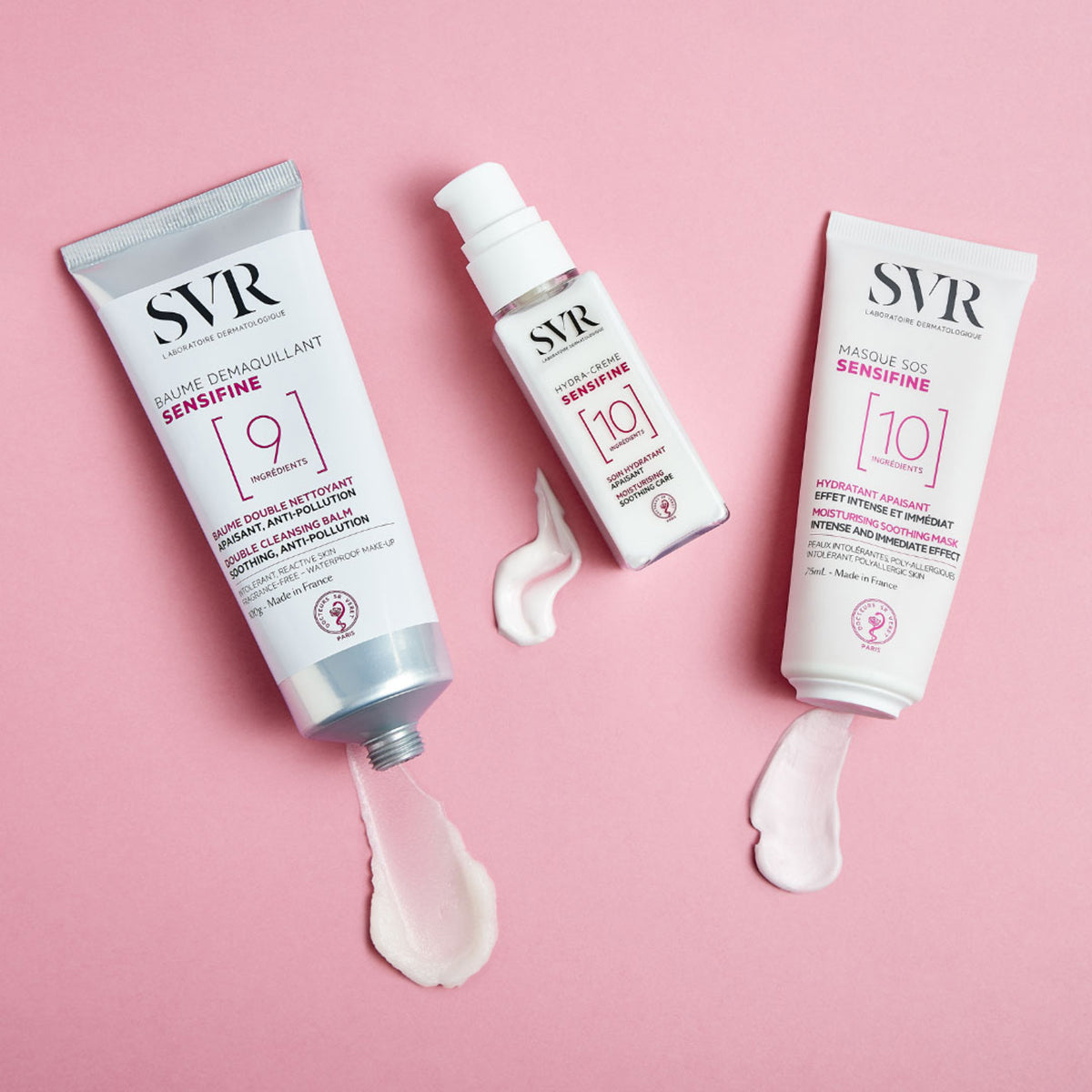 Trois produits SVR Sensifine blancs avec des textures crème sur fond rose, incluant baume démaquillant, hydra-crème et masque SOS.