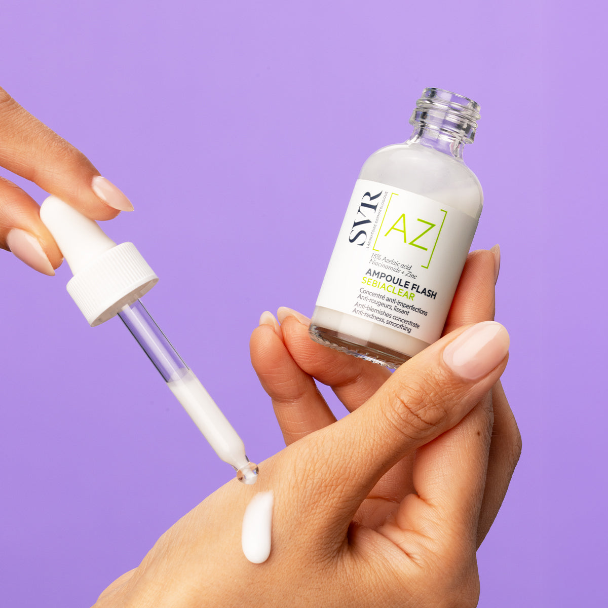 Flacon de soin SVR Sebiaclear Ampoule Flash avec pipette déposant une goutte de sérum lacté sur la main, fond violet.