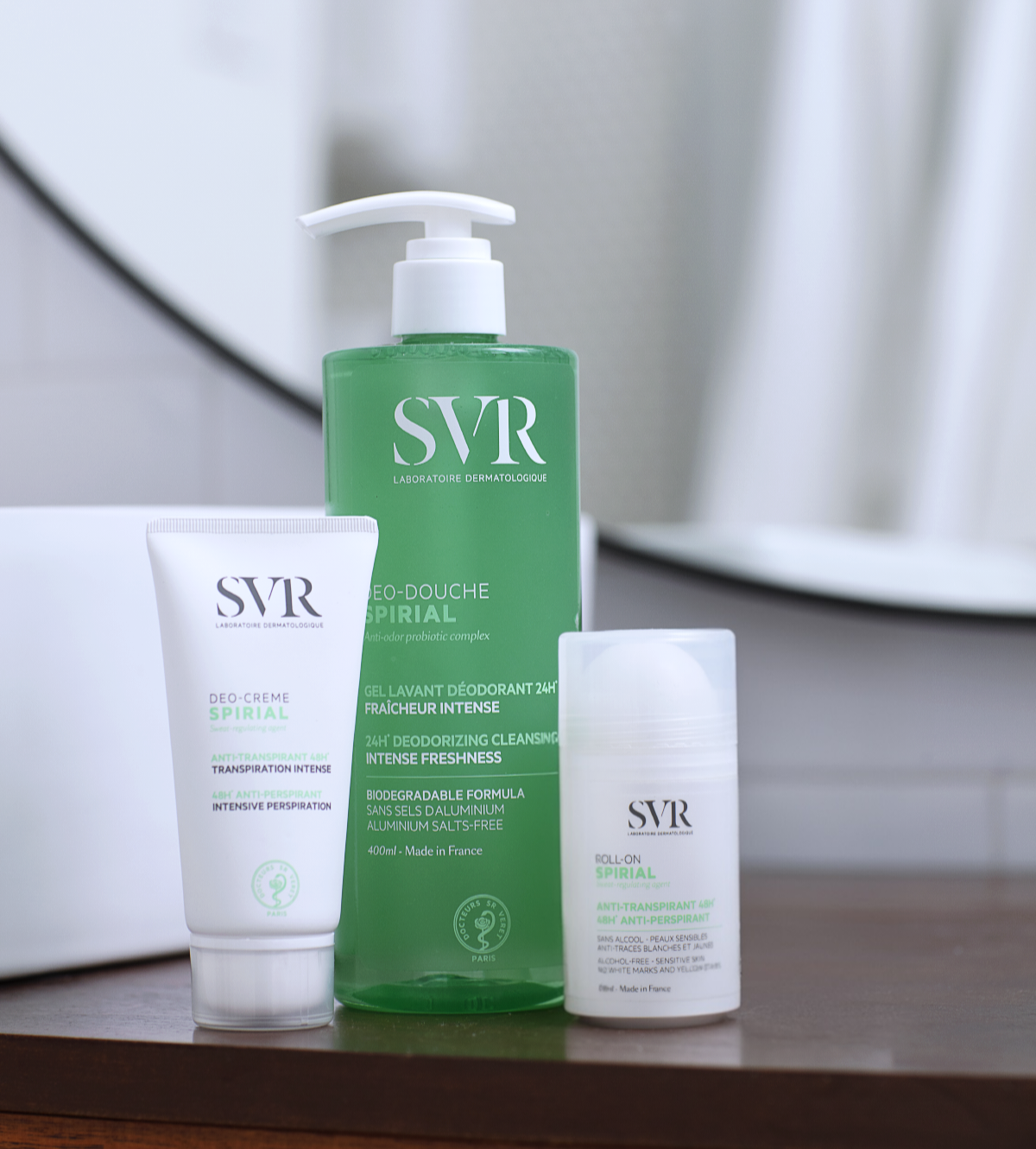 Trois produits SVR Spirial : un gel douche vert à pompe, une crème déodorante en tube blanc et un déodorant bille blanc.